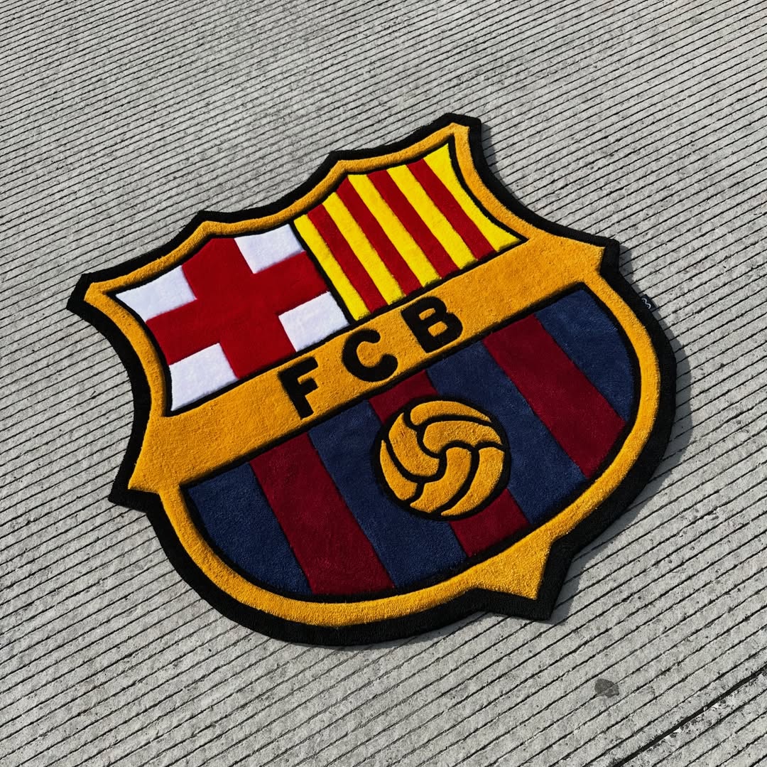 Plush FC Barcelona logo rug featuring shield with red cross, yellow stripes, FCB text