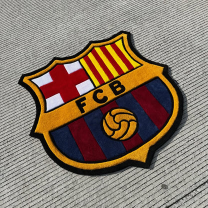 Plush FC Barcelona logo rug featuring shield with red cross, yellow stripes, FCB text