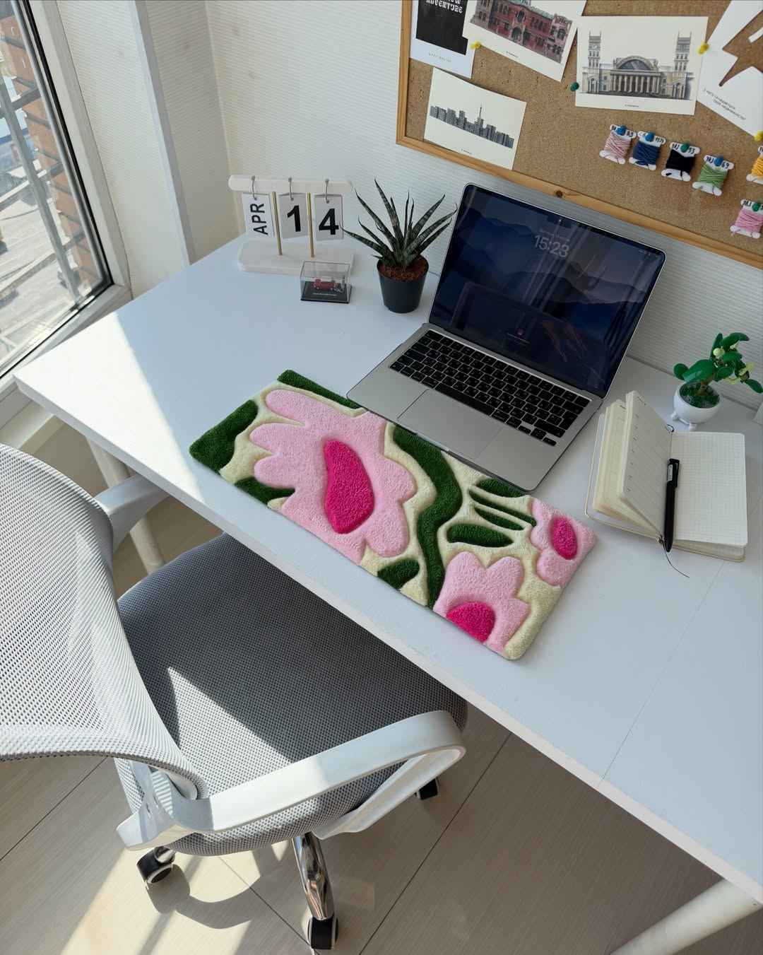 Handmade tufted floral desk mat in green with pink petal and heart shapes