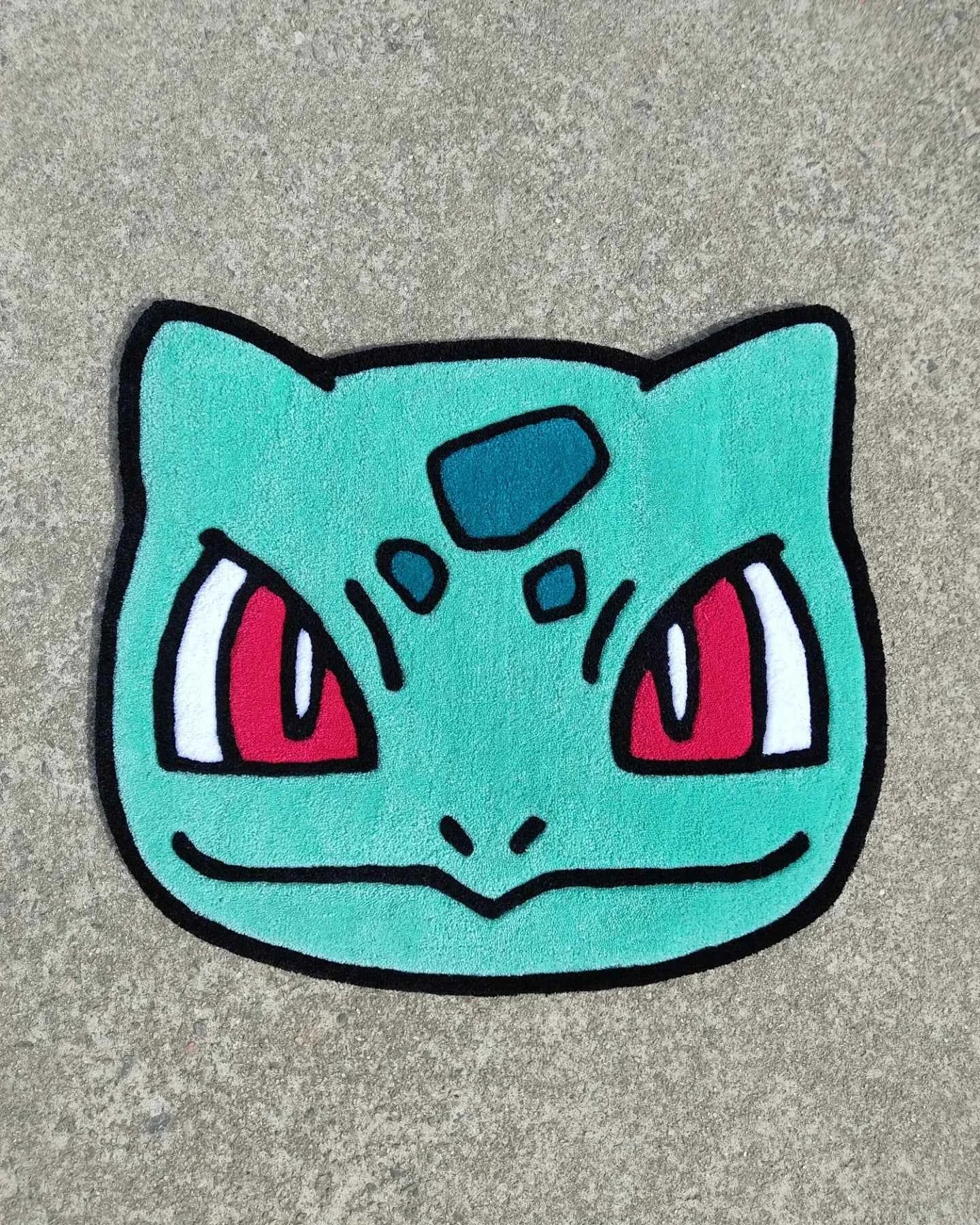 Bulbasaur head rug, turquoise face with red eyes and black outline border