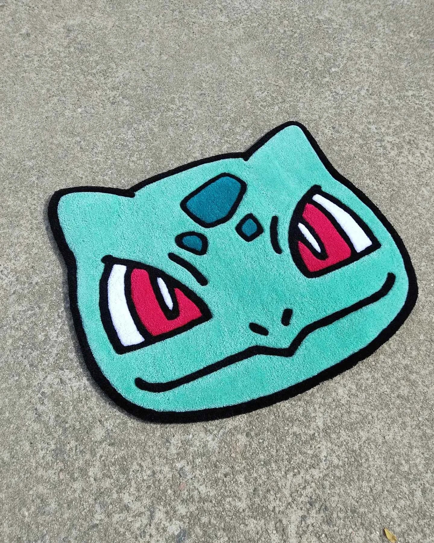 Bulbasaur character head rug in turquoise with pink and black facial details