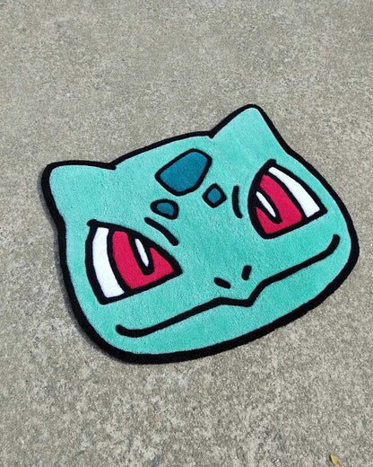 Bulbasaur character head rug in turquoise with pink and black facial details